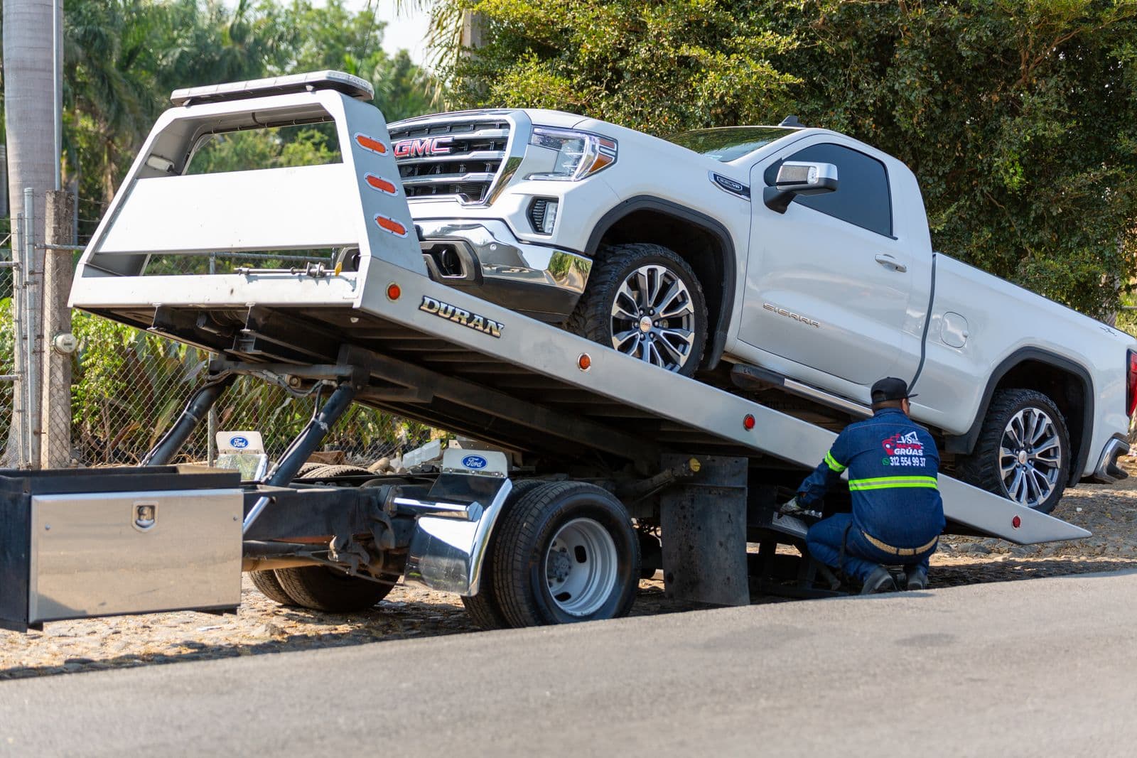 Licensed RapidHook Towing operator loading a pickup truck onto a flatbed tow truck
